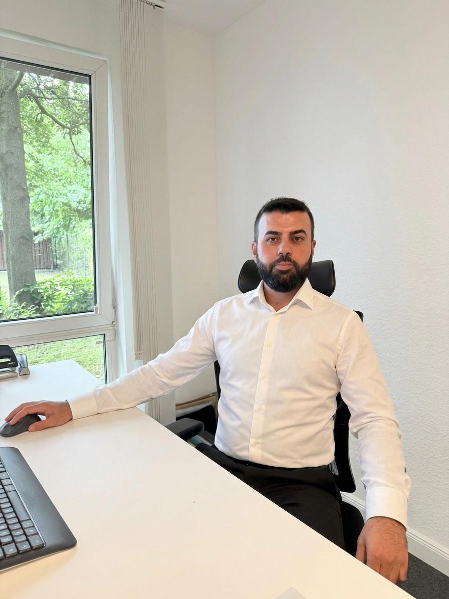 Mitarbeiter am Schreibtisch am Fenster mit Blick in den Garten
